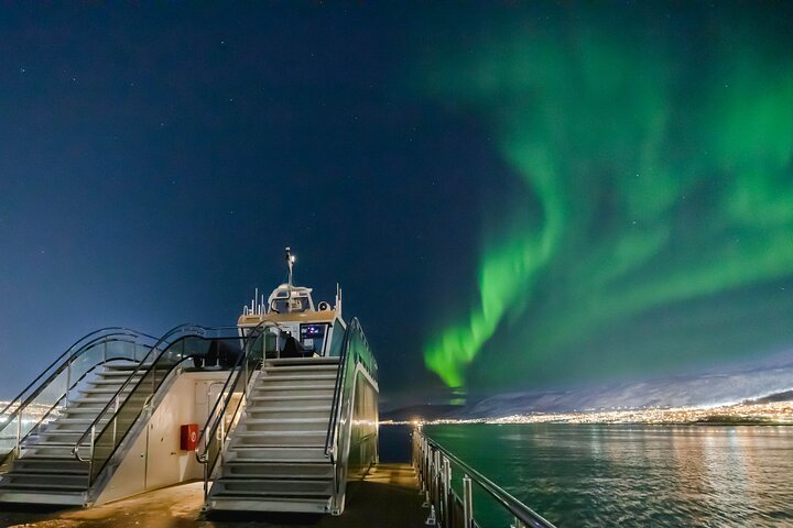Experience a cozy dinner on the water surrounded by the dancing light of the Northern Lights as you savor locally sourced dishes amidst Tromsø's stunning scenery.