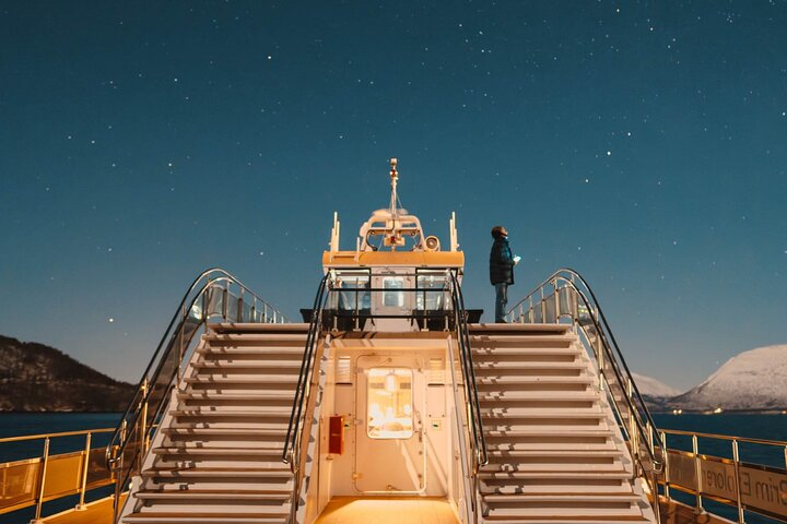 Experience the serene beauty of the Arctic nights aboard the Electric Northern Lights Cruise surrounded by stunning landscapes and the possibility of witnessing the mesmerizing dance of the auroras.