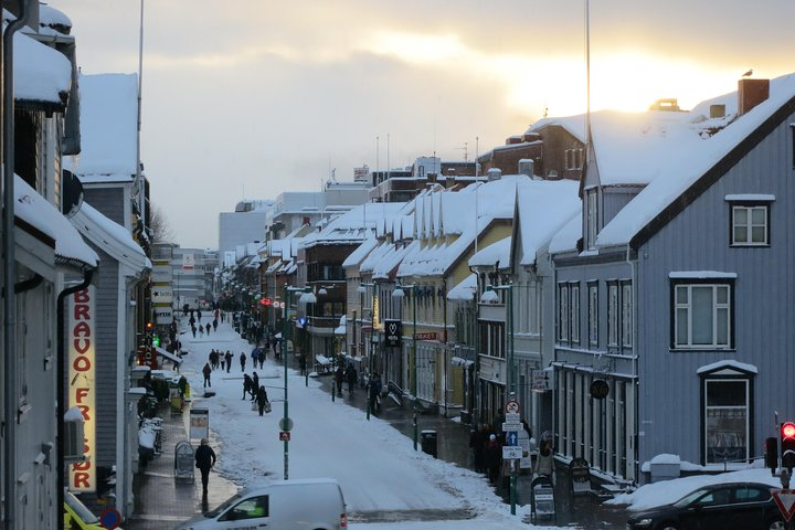 Explore Tromsø's charming streets lined with historic wooden houses and stunning landmarks immersing yourself in the city’s fascinating history as snow gently blankets the ground.