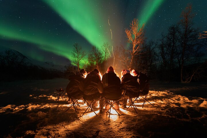 Experience the magic of the Aurora Borealis while staying warm by the fire with fellow adventurers. Capture unforgettable moments in the Arctic night surrounded by stunning natural beauty.