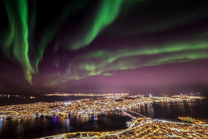 Experience Tromsø from above as the stunning northern lights dance overhead. Enjoy local treats while a guide shares the magic of this breathtaking destination. An unforgettable adventure awaits.