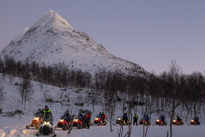 Experience the beauty of snow-covered mountains as you zip across the frozen landscape creating lasting memories with friends and family on an unforgettable snowmobiling adventure.