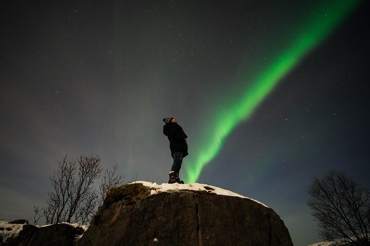 Witness the stunning display of the Northern Lights illuminating the night sky creating an unforgettable experience amidst the serene beauty of Tromsø's natural landscape. Perfect for adventure seekers.