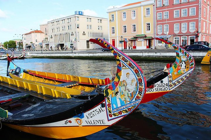 Experience the charm of Aveiro's colorful boats as they glide through tranquil waters framed by picturesque buildings offering a delightful glimpse into Portugal's rich maritime heritage.
