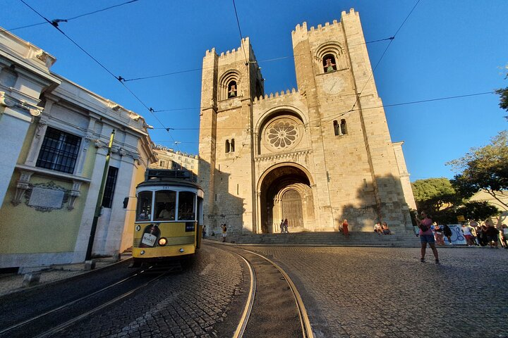Explore the charm of Lisbon's historic Cathedral where ancient architecture meets the lively energy of the iconic yellow tram. Experience centuries of history at every turn in this scenic backdrop.