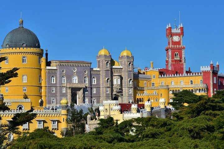 Experience the stunning architecture of Pena Palace a colorful gem nestled in lush surroundings perfect for explorations with family and friends while savoring local cuisine along the way.