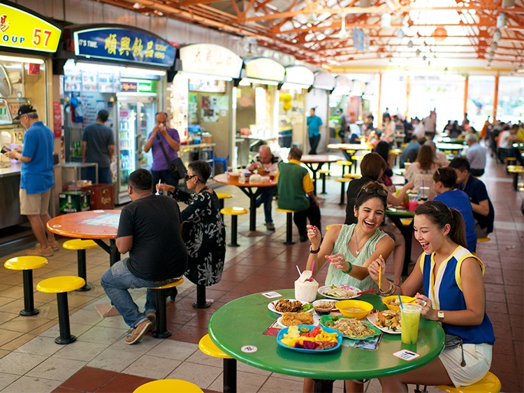 Discover the hustle and bustle of Singapore's hawker centres as locals savor authentic dishes and share smiles over plates of delicious food bringing genuine flavors to life.