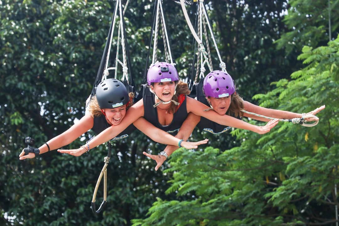 Experience the excitement of the Giant Swing at AJ Hackett where participants embrace the rush of flying through the air surrounded by lush greenery and breathtaking views.