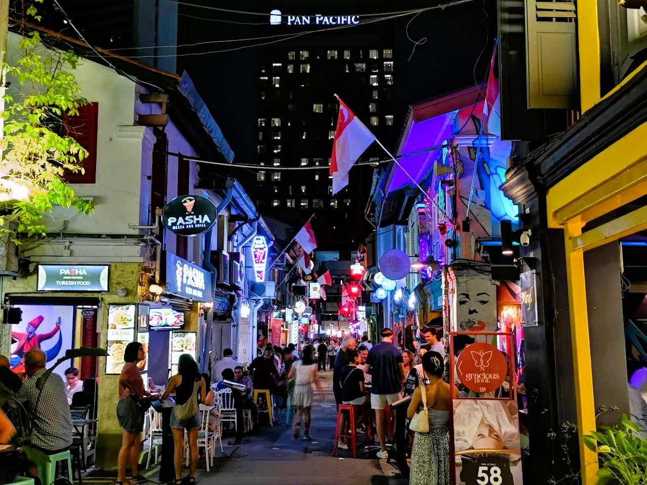 Scooter through lively streets adorned with colorful lights and flags savoring street food delights in dynamic neighborhoods that showcase the multicultural essence of Singapore. Adventure and taste await!