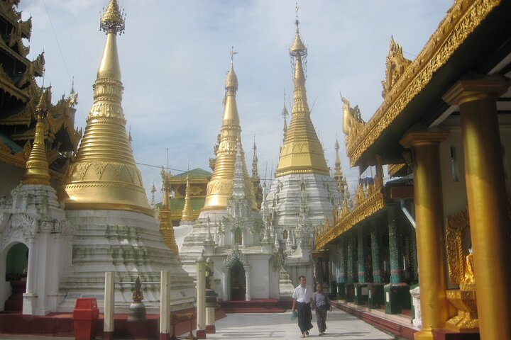 Golden spires shimmer under the sun inviting exploration within historic grounds. Experience the serenity and rich culture at the iconic Shwedagon Pagoda and surrounding landmarks in Yangon.