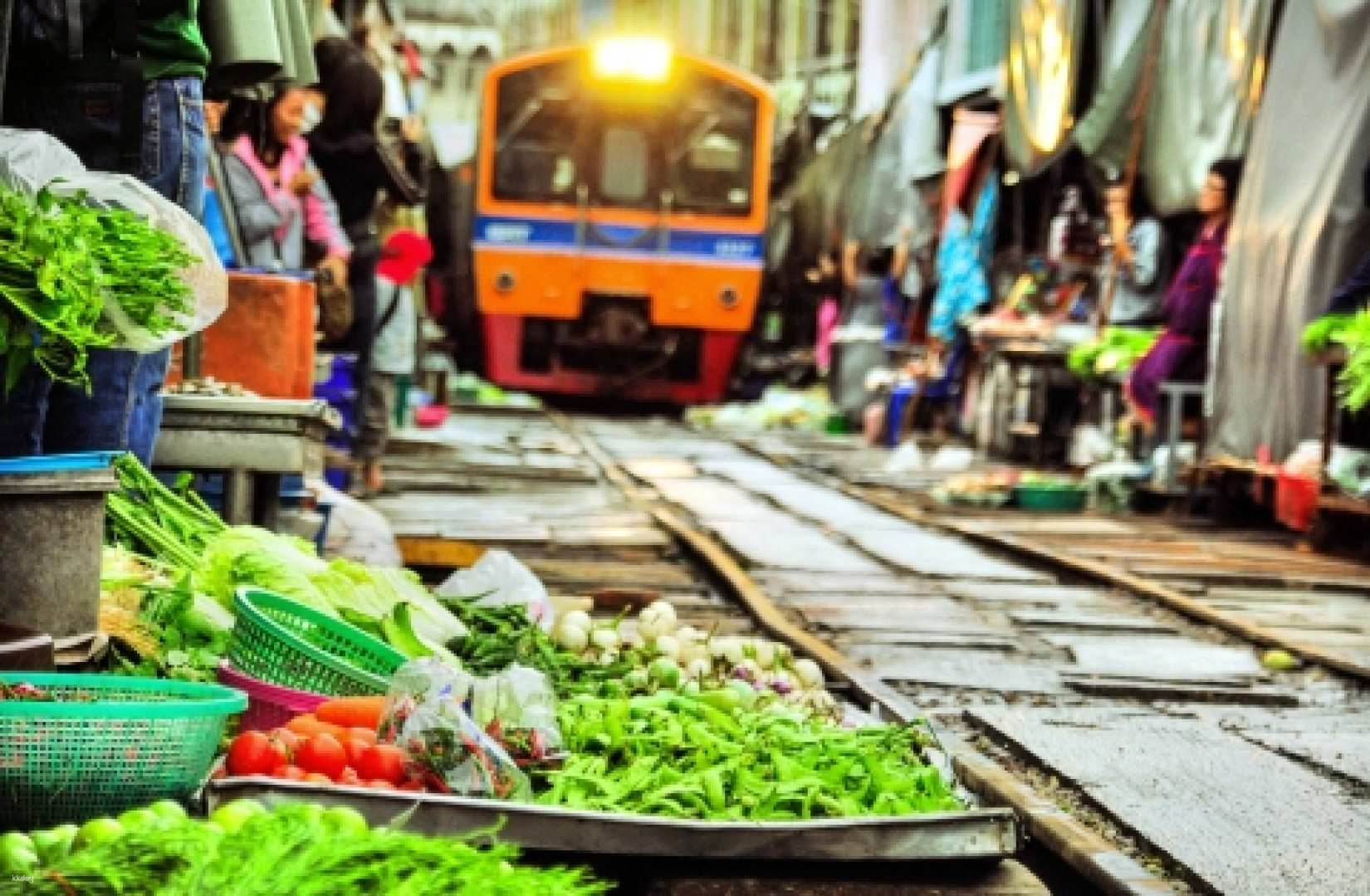 Experience the unique charm of Maeklong Market where fresh produce lines the tracks just as a train approaches blending daily life with the excitement of the unexpected.