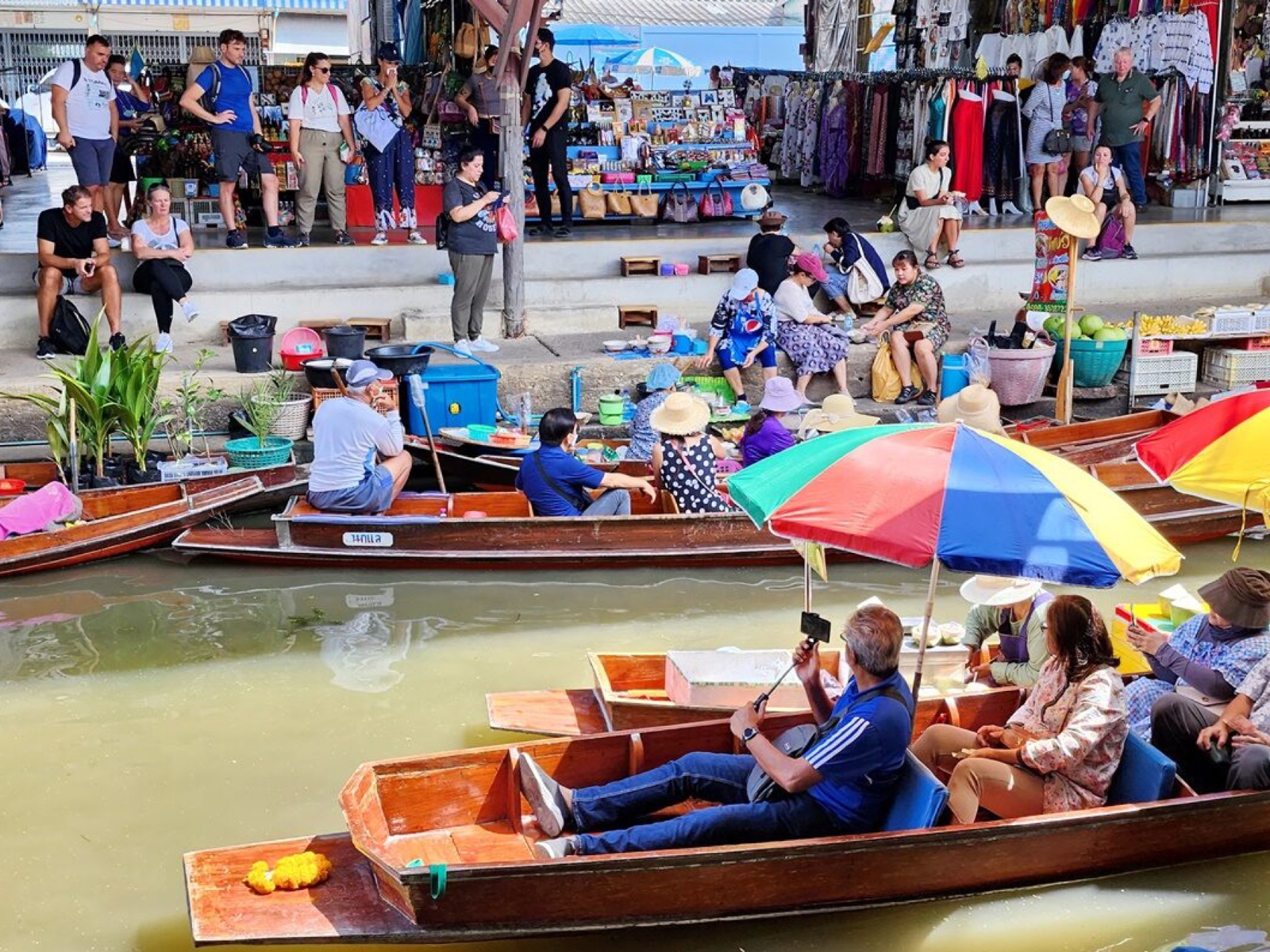 Experience the charm of Bangkok’s floating market where colorful boats glide through lively waters offering unique local goods and delightful moments amidst traditional Thai culture.
