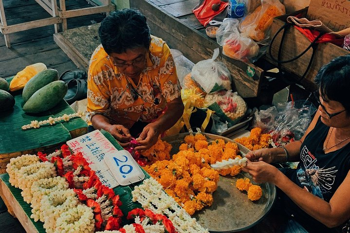 Explore the bustling flower market of Bangkok where local artisans craft beautiful garlands and indulge in the rich tastes and traditions of Thai street food culture.