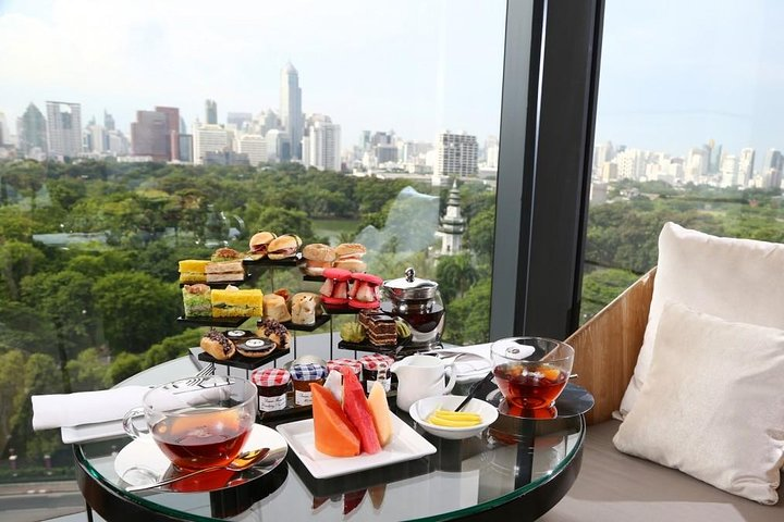 Indulge in a serene afternoon tea experience with a stunning city view featuring delectable pastries savory bites and premium teas for a delightful culinary escape in Bangkok.