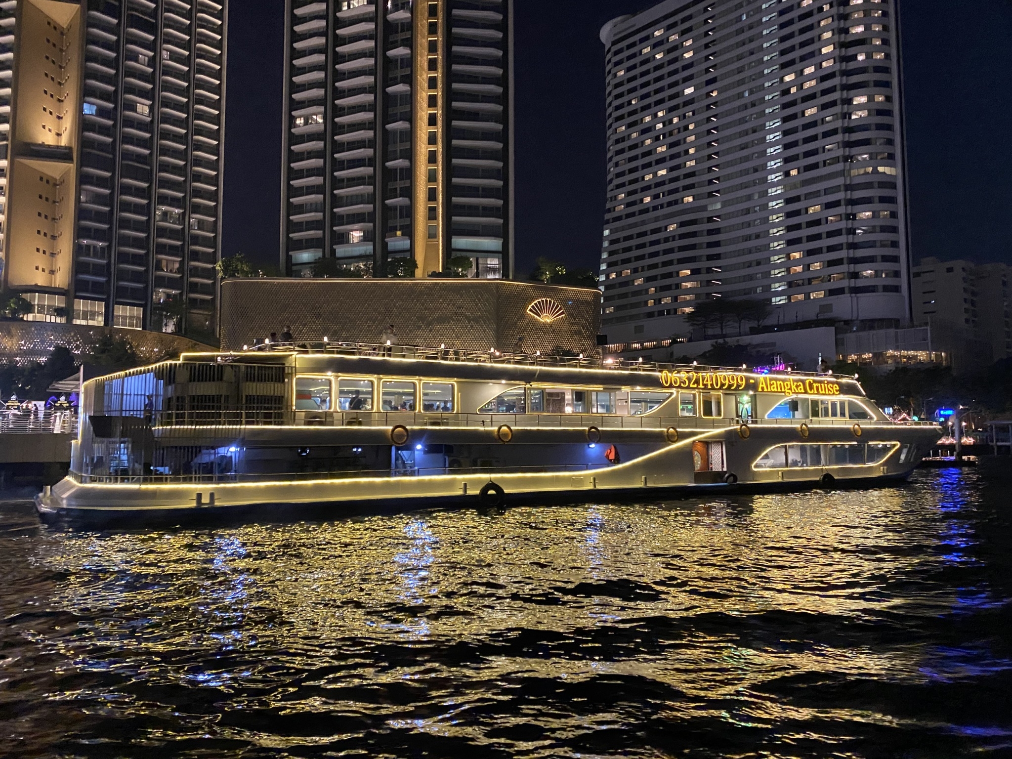 Experience a delightful evening on the Chao Phraya River savoring exquisite cuisine and enjoying live music while taking in stunning views of Bangkok's iconic landmarks illuminated at night.