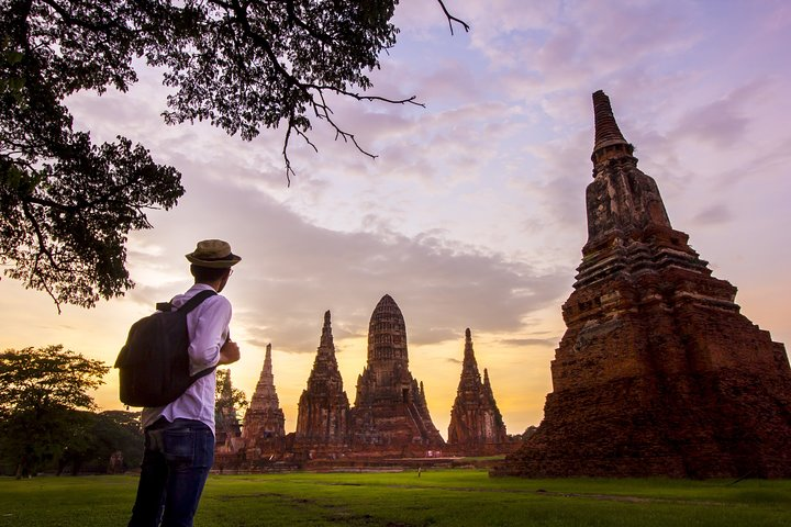 Explore the rich history of Ayutthaya as you wander through ancient ruins uncovering legends and stories that reveal the city's significant past against a stunning sunset backdrop.