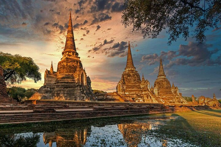 Experience the magic of Ayutthaya's stunning temples at sunset as you cycle through historic sites uncovering stories and secrets with an expert guide in a memorable adventure.