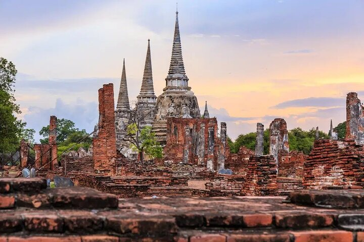 Explore the ancient ruins of Ayutthaya where majestic temples rise against serene skies revealing the remarkable history of Thailand's former capital. A journey through time awaits.