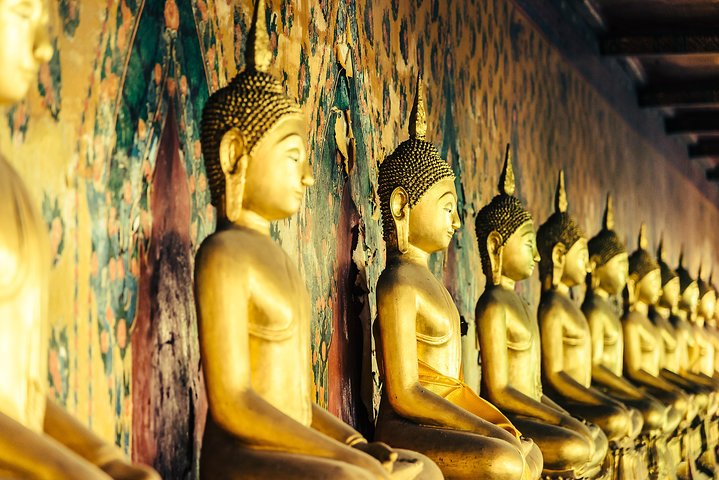 Discover the rich history of Thailand as you wander among golden Buddha statues each telling stories of the past within magnificent temple grounds that reflect intricate architectural beauty.