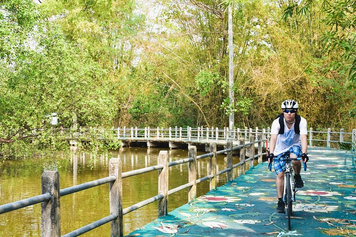 Ride through lush greenery along peaceful paths discovering hidden gems of Bangkok while enjoying the tranquility of nature and local culture at Bang Krachao Island.