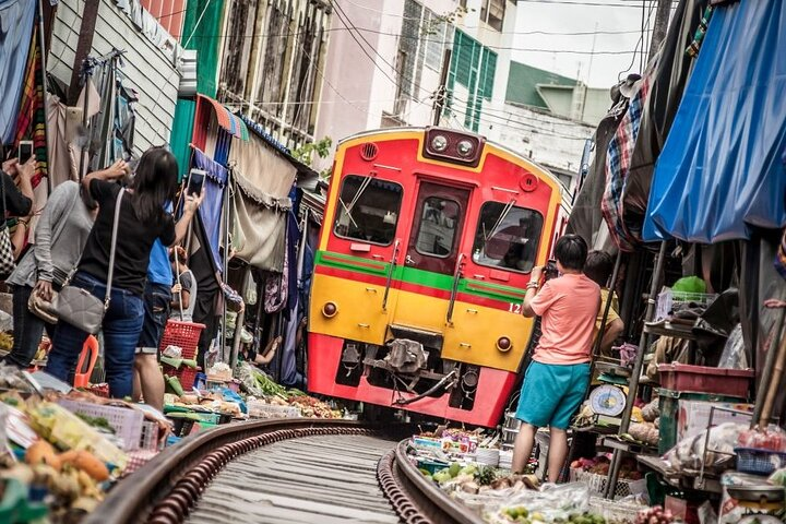 Experience the unique thrill of the train passing through the bustling Maeklong Railway Market where vibrant stalls and local life blend seamlessly with the excitement of passing trains.