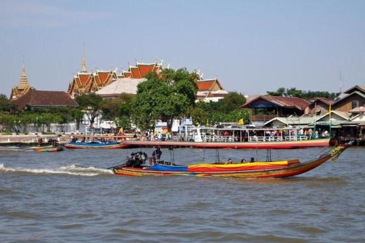 Experience the charm of Bangkok as long-tail boats glide through serene canals revealing stunning sights like the iconic Temple of Dawn amidst lush landscapes and traditional riverside life.
