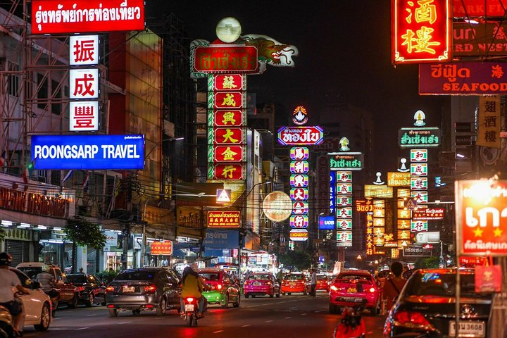 Experience the lively streets of Yaowarat at night where colorful neon signs illuminate the bustling scene inviting you to savor delicious street food and explore unique local shops.