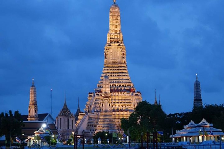 Experience the charm of Bangkok and Thonburi as you cycle past illuminated temples and serene waterways discovering the city's rich history and unique scenery under the evening sky.