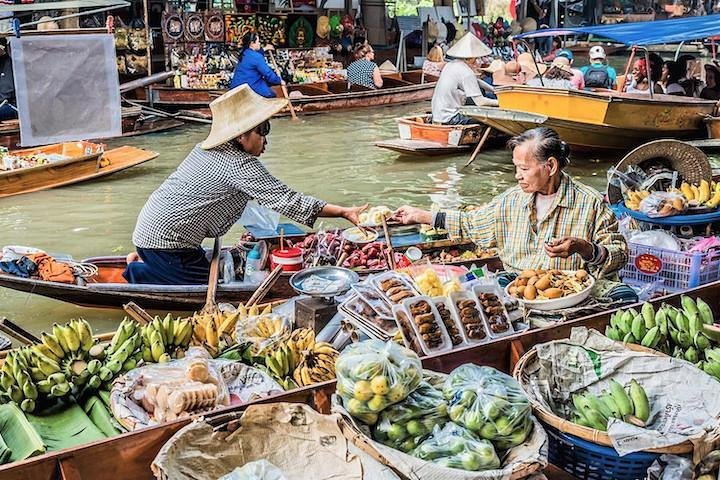 Experience the bustling life of Bangkok’s floating market where vendors sell fresh produce from colorful boats creating a picturesque scene perfect for capturing memories and immersing in local culture.