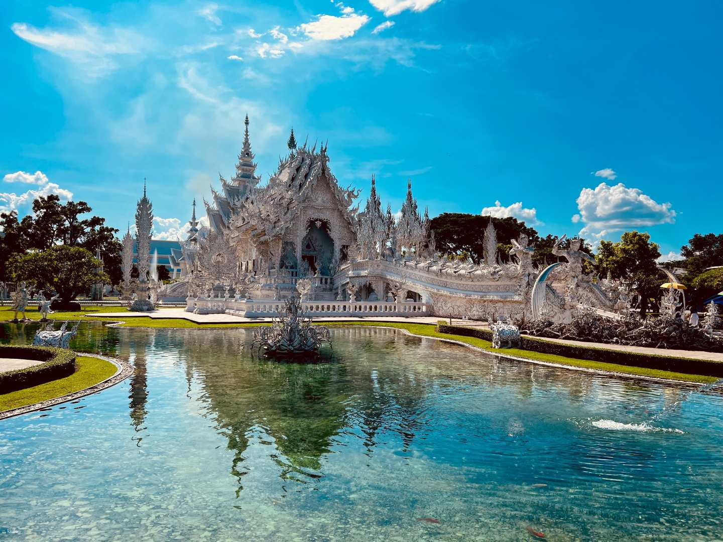 Discover the stunning design of the White Temple with its intricate details reflected in the tranquil waters a perfect highlight of Chiang Rai’s remarkable sights.