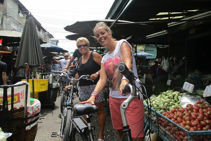 Explore the charm of Bangkok on two wheels weaving through bustling markets and savoring local flavors during a leisurely bicycle tour and floating market experience.