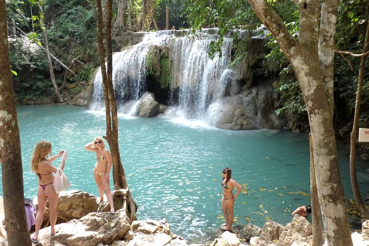 Immerse yourself in stunning nature with Erawan Waterfall's clear turquoise waters and limestone cliffs perfect for a refreshing dip and unforgettable memories amidst lush greenery.