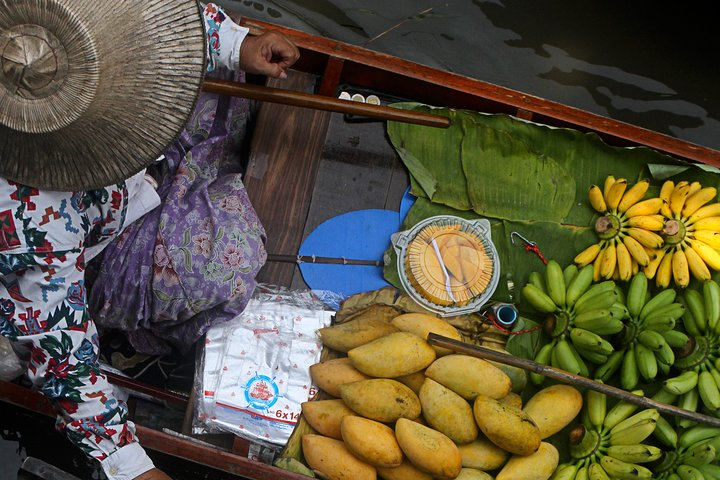 Experience the charm of Thai culture as colorful fruits float by on traditional boats creating a delightful scene at the Floating Market a true feast for the senses.