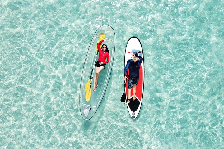 Experience the tranquility of Haadtien Beach as you glide over crystal-clear waters on kayaks and SUP boards creating unforgettable memories in a serene coastal paradise.