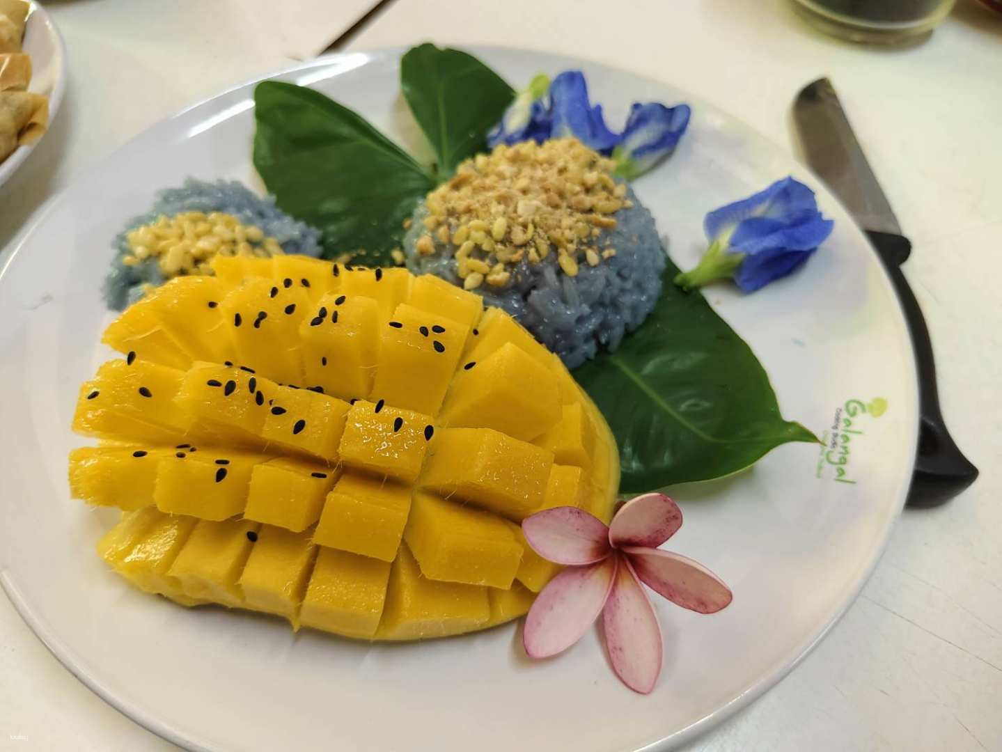 Discover the art of preparing traditional Thai dishes featuring a stunning plate of mango with fragrant sticky rice embraced by unique local ingredients and culinary creativity. Delight in every bite!