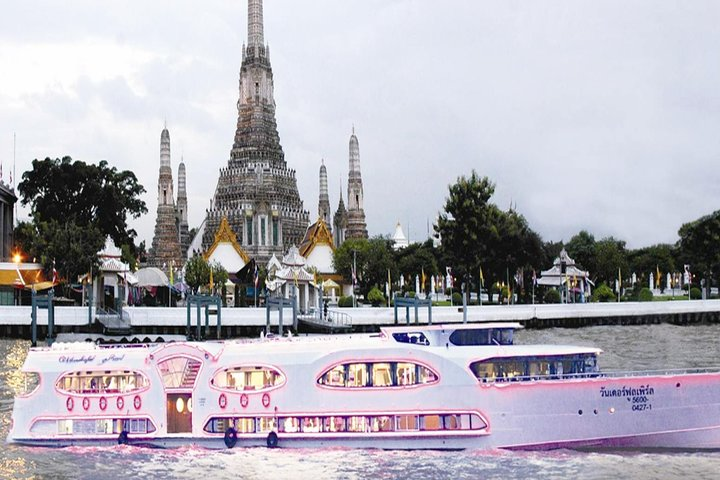 Experience a delightful evening on the Chao Phraya River where a beautiful boat serves delicious dishes live music and stunning views of Bangkok's illuminated landmarks.
