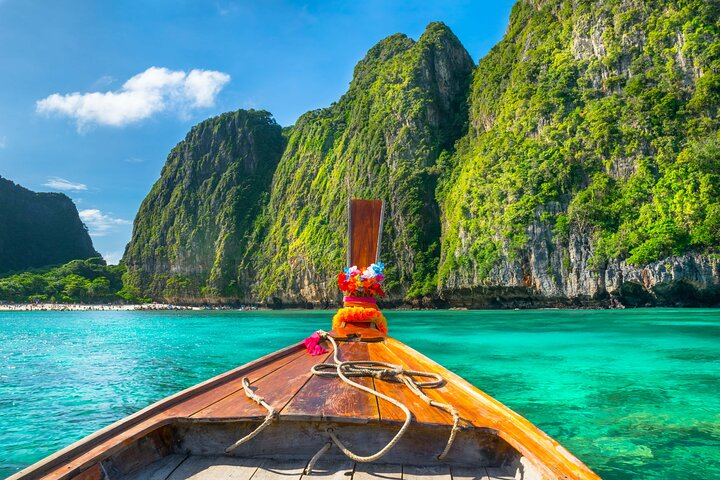 Discover the stunning beauty of Thailand's coast as you glide through crystal-clear waters surrounded by towering cliffs and lush greenery perfect for unforgettable adventures and relaxation.