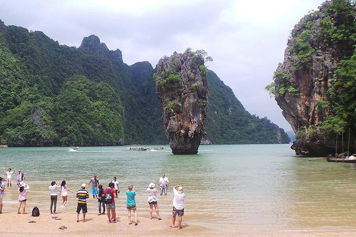 Experience the stunning limestone karsts of Phang Nga Bay where visitors admire the iconic James Bond Island and enjoy unique river explorations and the charm of local villages.