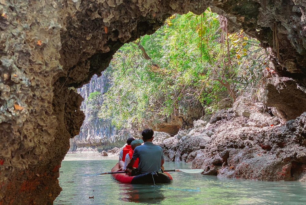 Paddle through serene waters surrounded by limestone cliffs and lush greenery discovering hidden gems in Phang Nga Bay while enjoying a relaxing day amidst nature's beauty.