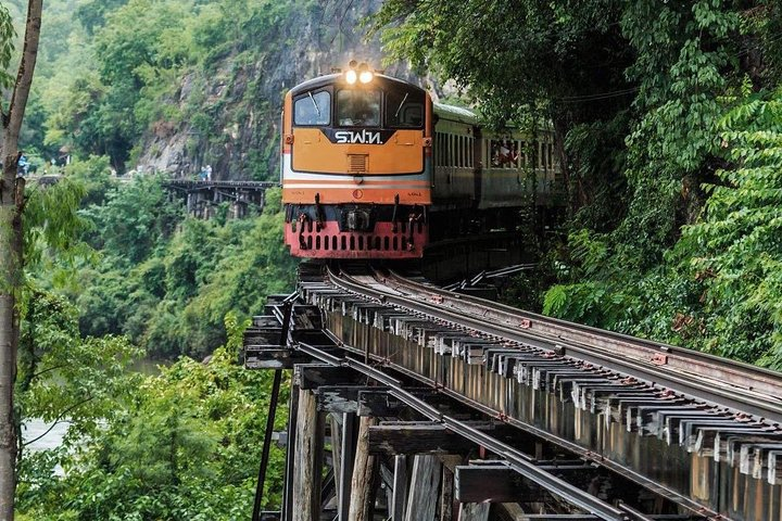 Experience the unique journey along the iconic Death Railway where history and nature blend seamlessly amidst lush greenery and stunning landscapes highlighting Kanchanaburi's significant past.