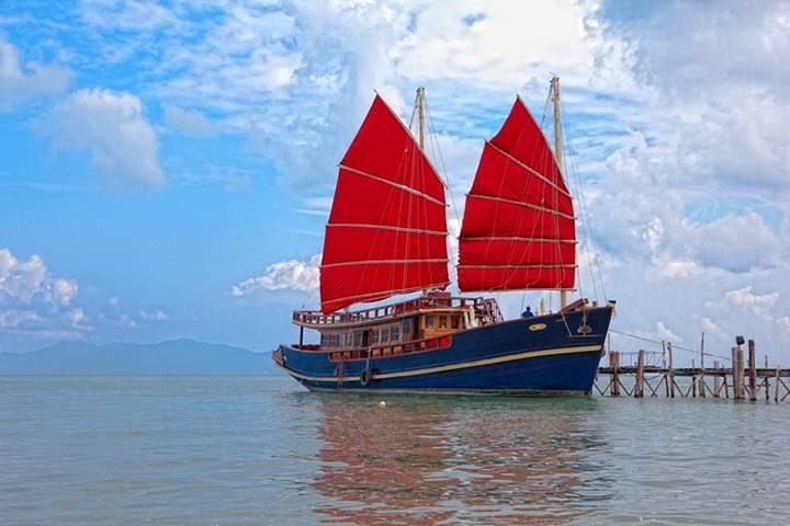 Set sail on a spacious yacht with striking red sails exploring hidden beaches and enjoying a delightful brunch in the serene waters surrounding Koh Phangan. Relax and snorkel in paradise.