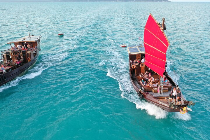 Experience the joy of sailing on a traditional junk boat exploring pristine beaches and snorkeling in crystal-clear waters all while enjoying delicious Thai cuisine amidst breathtaking coastal views.