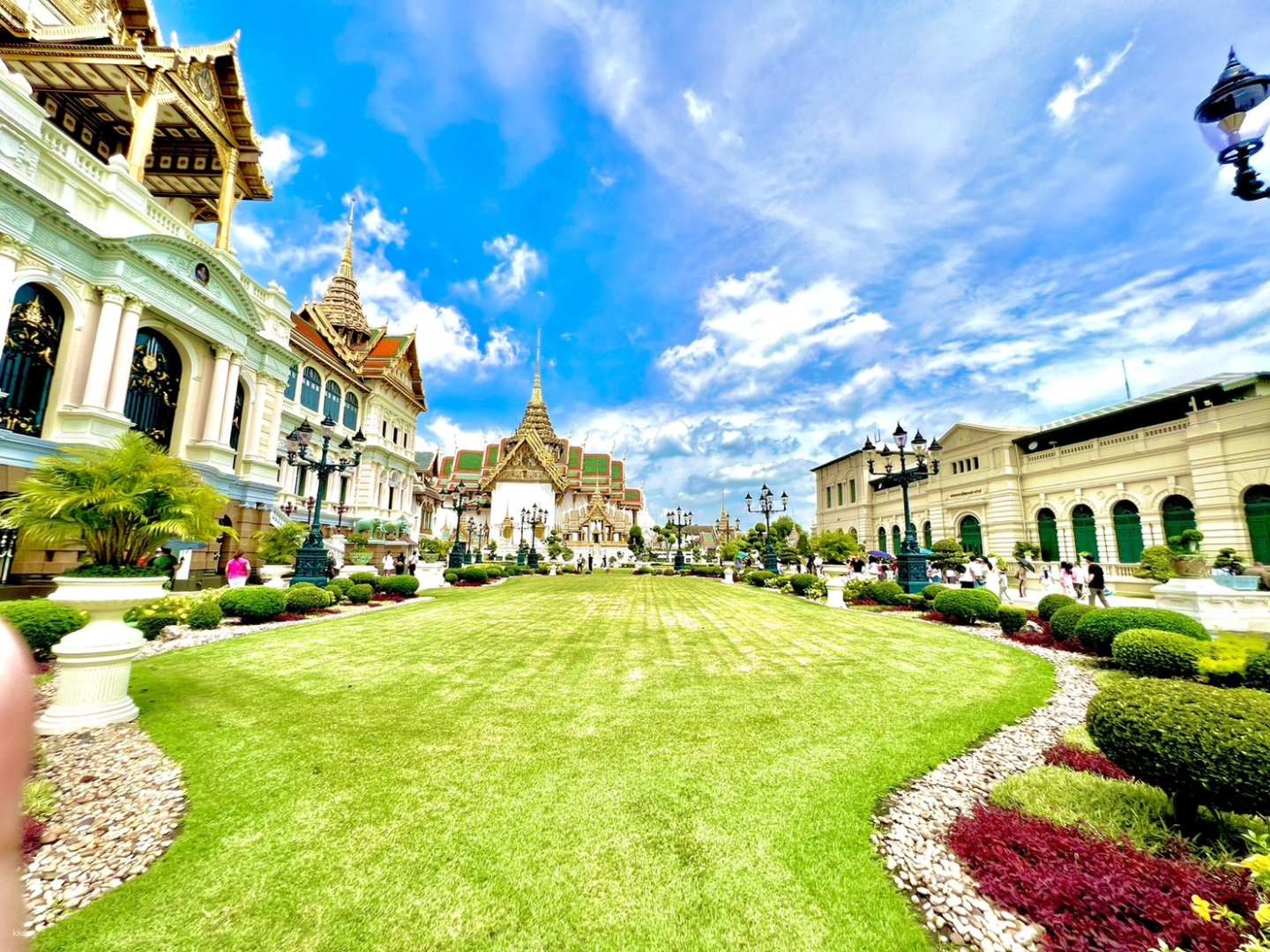 Experience the grandeur of Bangkok where lush gardens frame the stunning architecture of the Grand Palace and Wat Phra Kaew inviting exploration and cultural appreciation at every turn.