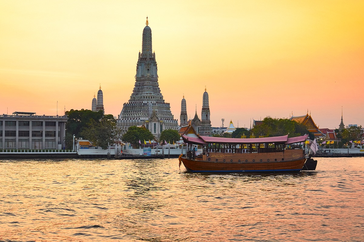 Experience the charm of Bangkok as you glide past the illuminated Temple of Dawn and historic sites savoring exquisite Thai cuisine on the beautifully restored Manohra rice barge.