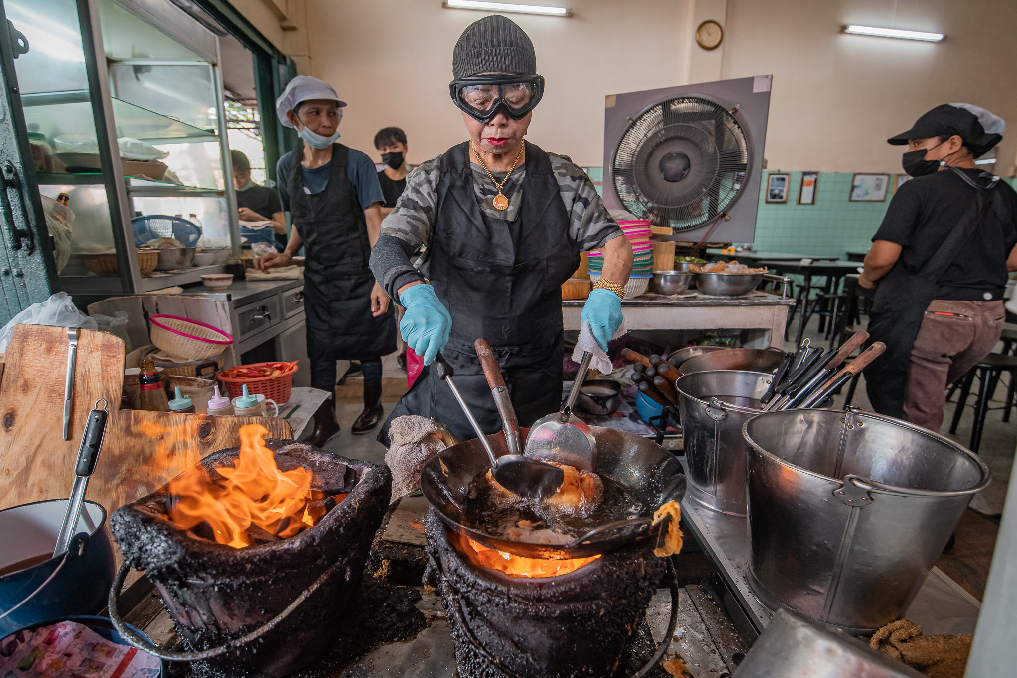 Experience the hustle of Bangkok's street food scene where skilled chefs craft delicious dishes over open flames offering a feast of flavors and aroma just waiting to be explored.
