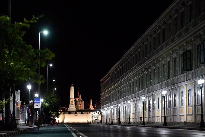 Experience the charm of Rattanakosin Island at night where illuminated landmarks like The Giant Swing stand amidst historic architecture revealing Bangkok's rich heritage on your cycling adventure.