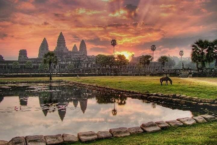 Experience the majestic Angkor Wat at sunrise where ancient temples reflect in tranquil waters offering an unforgettable glimpse into Cambodia's rich heritage and stunning landscapes.