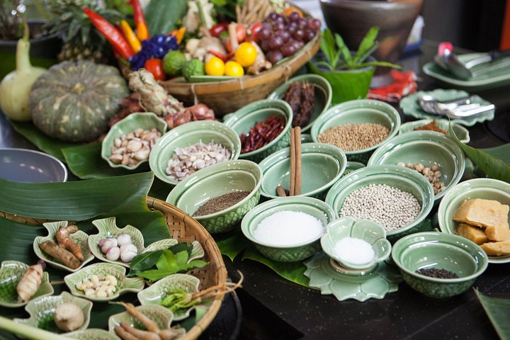 Immerse yourself in the rich flavors of Thailand with fresh ingredients spices and herbs ready for your culinary adventure guided by a local chef in a serene riverside setting.