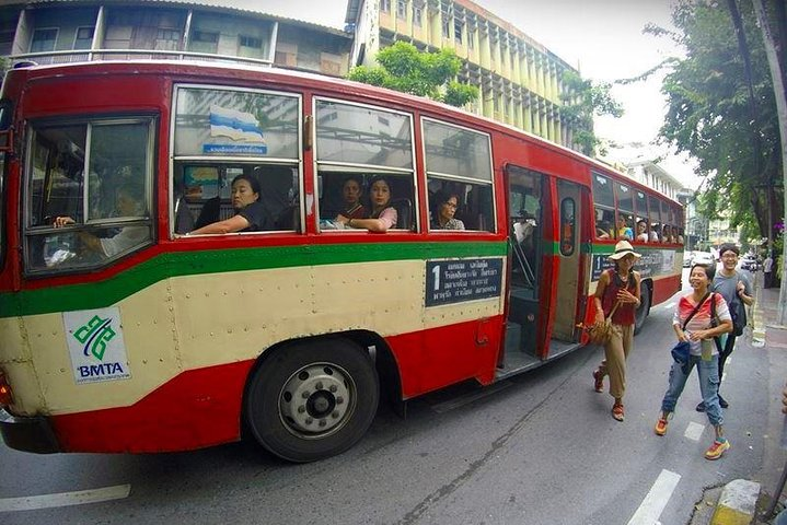 Explore Bangkok's local bus scene where colorful buses weave through bustling streets offering a unique glimpse into the city's daily life while savoring delicious snacks along the way.