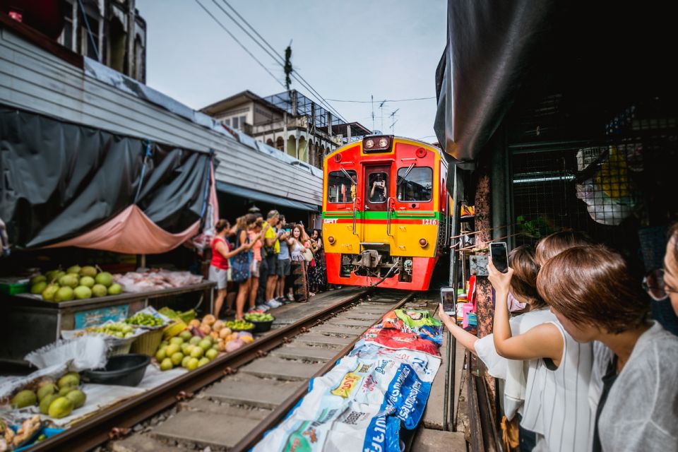 Experience the unique charm of Maeklong Railway Market where local vendors deftly clear their stalls for passing trains showcasing the lively interplay of market life and rail travel.